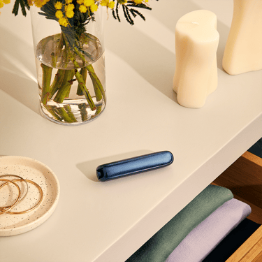 Ploom AURA front panel Navy Blue Augmented Pattern accessory on device, located on a table.
