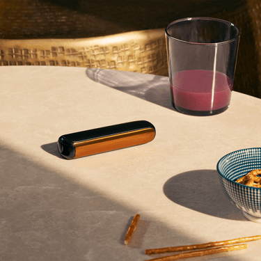 Ploom AURA front panel Mango Sorbet accessory attached to device on a table.
