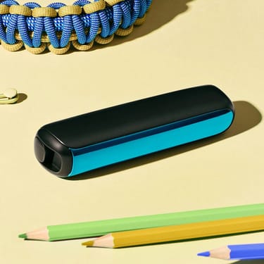 Bir masa üzerinde Ocean Blue renkli Ploom AURA ön panel aksesuarının yakın plan görüntüsü.
