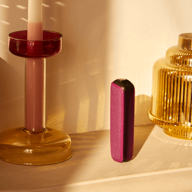 Ploom AURA Dark Orchid device standing on a table.