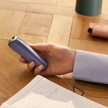 Hand showing Ploom AURA Back Cover Lavender accessory attached to device.
