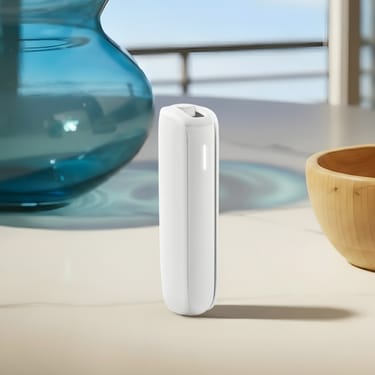 Masa üzerinde duran White Glacier arka kapaklı Ploom AURA cihazı.