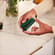 Hand placing an Amazon Green Back Cover on a Ploom AURA device